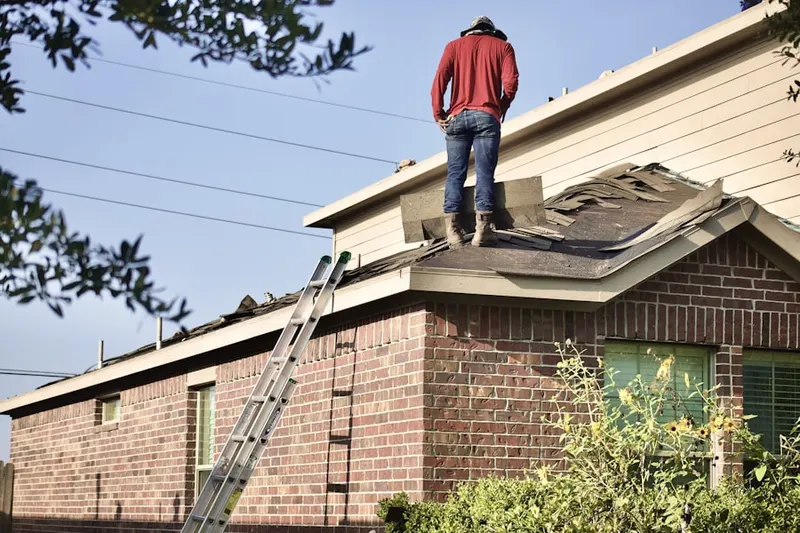 Professional roofer working on a residential roof in West Utica